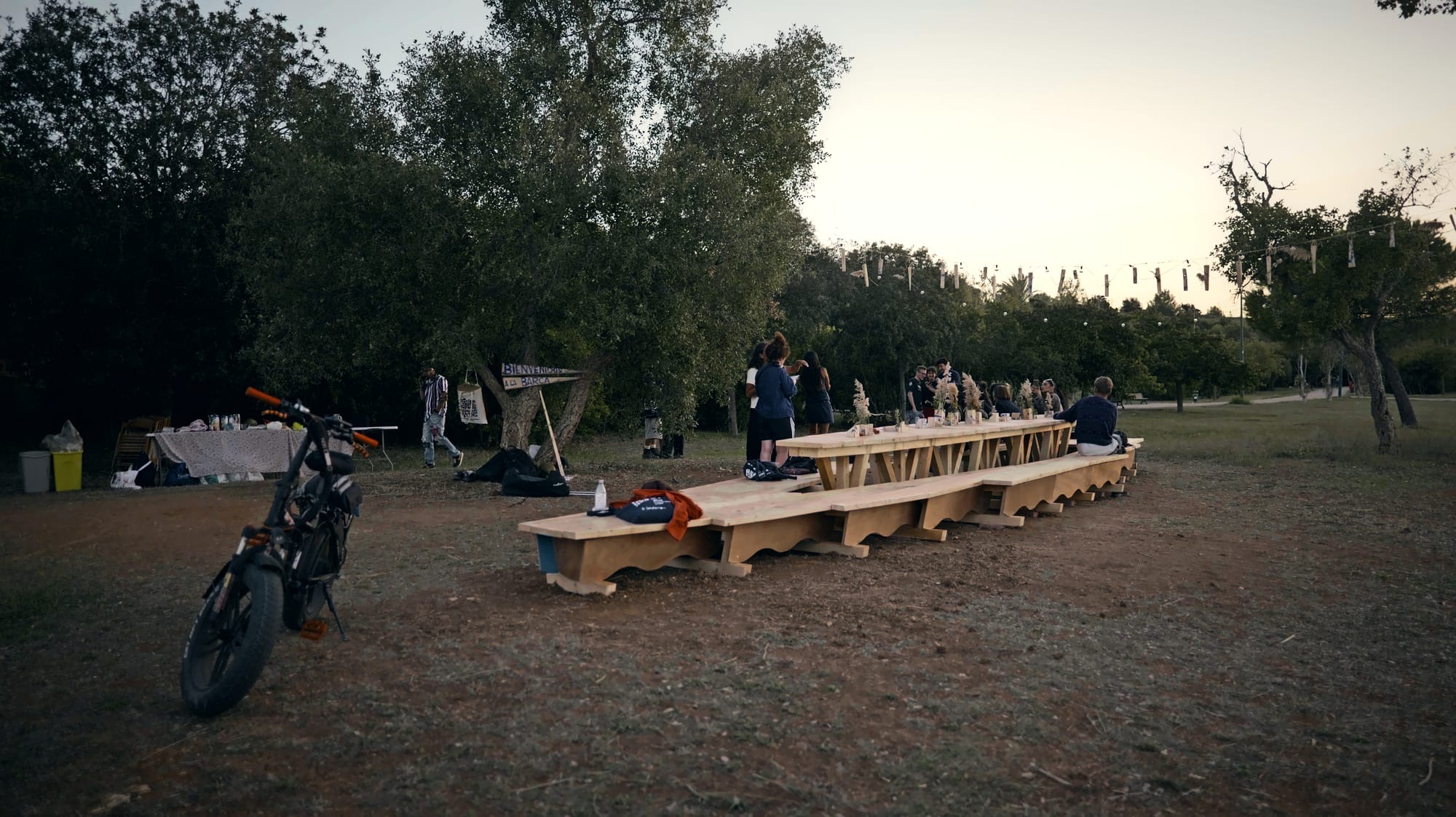 La Barca per tutta la sua lunghezza, al crepuscolo, con un gruppo di persone attorno al tavolo.