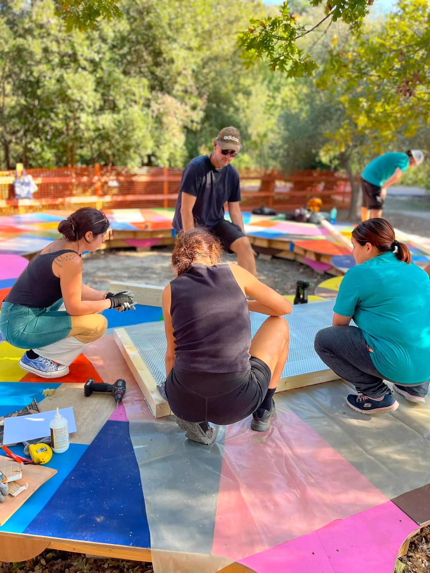Sull’Isola, usata come piano di lavoro, tre partecipanti montano il telaio di un pannello in rete.